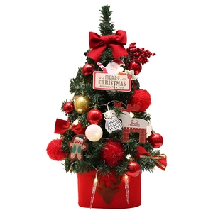 Mini tabletop Christmas tree with red velvet bow, LED lights, and festive ornaments