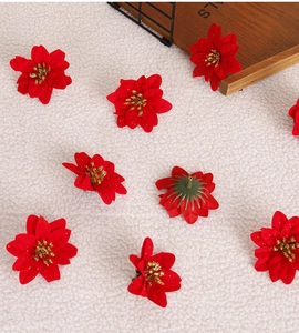 Close-up of 6cm red artificial poinsettia flowers with gold glitter for Christmas decor