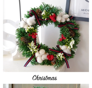Close-up of Christmas wreath with cotton bolls, pine cones, red berries and striped bow