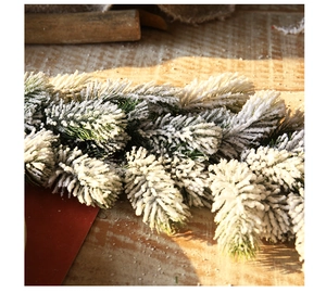 Close-up of 1.8m green artificial pine garland with dense white flocked snow texture
