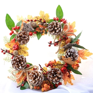 Detail of autumn wreath with maple leaves, pine cones, red berries and jute bow decoration