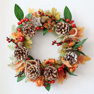 Detailed autumn wreath featuring pine cones, maple leaves, and a rustic burlap bow decoration