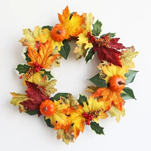 Detailed view of autumn wreath with maple leaves, mini pumpkins, and red berries on vine base