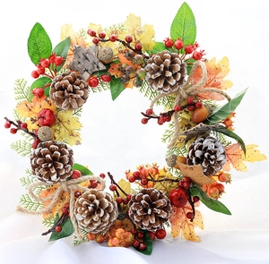 Close-up of autumn wreath featuring natural pine cones, red berries and maple leaves