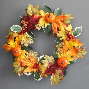 Detailed close-up of autumn wreath with maple leaves, mini pumpkins, and festive berries