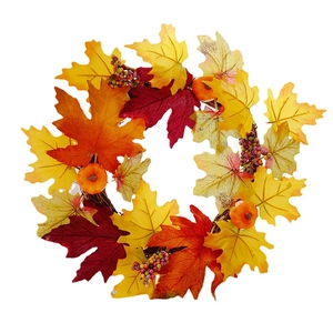 Autumn wreath with maple leaves and pumpkins on a natural rattan base for home decor