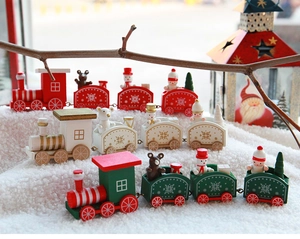 Detailed close-up of wooden Christmas train with miniature snowmen on white plush snow