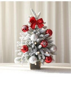 Primer plano de un árbol de Navidad nevado con lazo de terciopelo rojo y luces LED