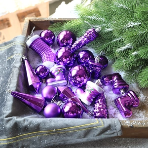 Lila Weihnachtskugeln Set mit Stiefeln und Zapfen in schneebedeckter Holzkiste