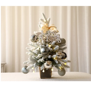 Primer plano de mini árbol de Navidad nevado con luces LED y adornos festivos