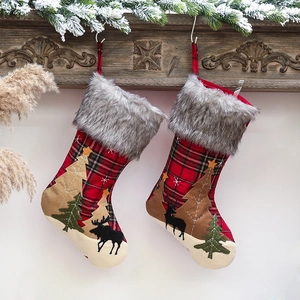 Lot de grandes chaussettes de Noël à carreaux rouges et noirs sur une cheminée