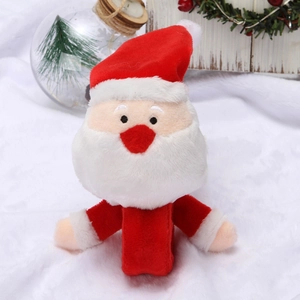Détail du bracelet peluche Père Noël sur fond de fourrure blanche avec décor de fête