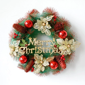Kerstkrans van dennennaalden met rode ballen, dennenappels en Merry Christmas bordje