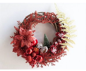 Close-up of red and gold Christmas wreath with pine cones and Merry Christmas sign