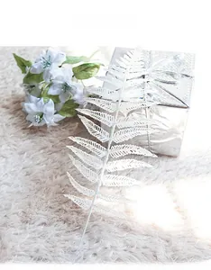 Close-up of white glitter fern leaf sprig for Christmas tree and wedding decoration