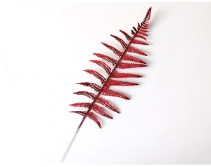 Macro detail of red glitter artificial fern leaf branch for Christmas tree decoration