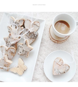 Handmade wooden Christmas ornaments set with heart, star and butterfly shapes on white silk ribbons