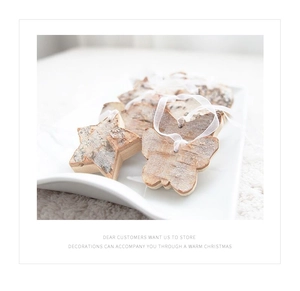 Macro view of wooden star and butterfly ornaments with ribbons in a white ceramic dish