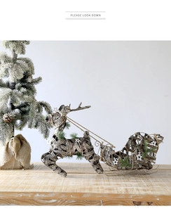 Détail de renne et traîneau en rotin faits main avec des accents festifs de sapin et étoile
