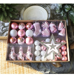 Detailed set of pink and white Christmas ornaments and star topper in a kraft gift box