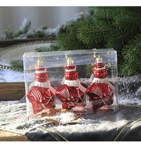 Close-up of red star-shaped Christmas ornaments with white glitter in transparent box