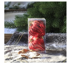 Close-up of heart-shaped red Christmas ornaments on snow and pine branches in a box