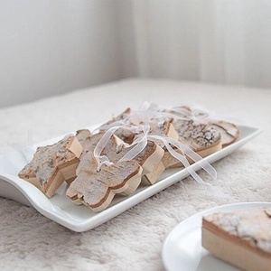 Rustic wood heart and star ornaments with white ribbons on a white plush rug decoration