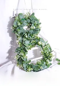Detailed texture of silk eucalyptus leaves and small white flowers on a festive wreath