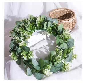 Detail of Nordic artificial eucalyptus wreath with small white flowers on a rustic background
