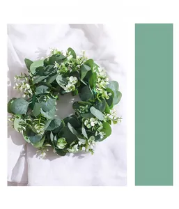 Detailed view of artificial eucalyptus wreath with dense green leaves and small white flowers