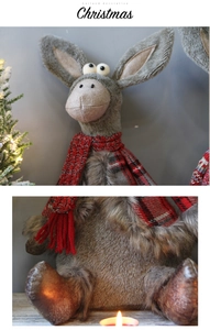 Detail of plush Christmas donkey ornament with red plaid scarf and soft grey fur texture