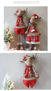 Detail of Christmas reindeer plush figurines in festive red plaid outfits and hats