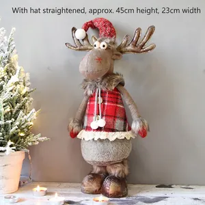 Detail view of plush reindeer Christmas doll with red plaid vest and knit hat ornaments