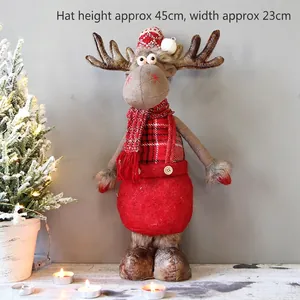 Detail of plush Christmas elk doll with knitted hat and plaid scarf on festive wood table