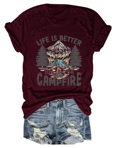 Flat lay of maroon campfire graphic t-shirt paired with distressed blue denim shorts