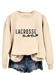 Detail of cream sweatshirt with Lacrosse Mom print paired with denim shorts
