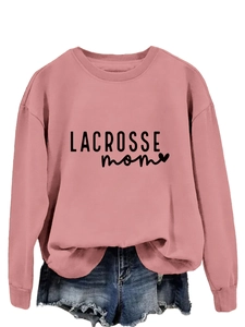 Detailed close-up of pink Lacrosse Mom sweatshirt paired with frayed denim shorts