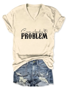 Detail of V-neck cream t-shirt with Somebody's Problem print and cowboy hat icon