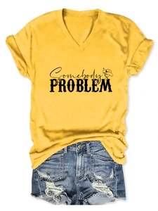 Flat lay of bright yellow V-neck tee with Somebody's Problem print and denim shorts