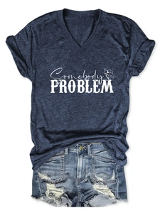 Flat lay of navy V-neck T-shirt with Somebody's Problem print and ripped denim shorts