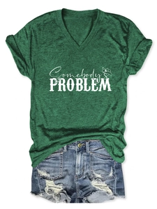 Flat lay of a dark green V-neck T-shirt with Somebody's Problem print and denim shorts