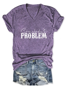 Detail of purple V-neck T-shirt with Somebody's Problem print and denim shorts