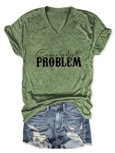Flat lay of green V-neck T-shirt with Somebody's Problem print and denim shorts