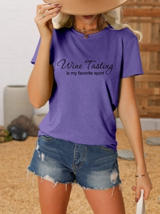 Detail of purple Wine Tasting graphic tee paired with denim shorts in a sunny outdoor setting
