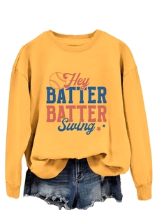 Détail du sweat-shirt de baseball jaune avec l'imprimé du slogan Hey BATTER BATTER Swing