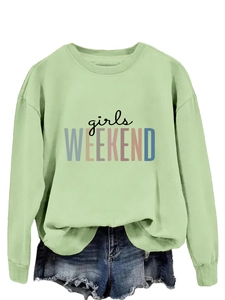 Détail du sweat-shirt vert clair avec imprimé Girls Weekend et finitions côtelées