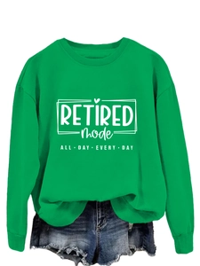 Close-up of grass green crewneck sweatshirt featuring white Retired Mode slogan print