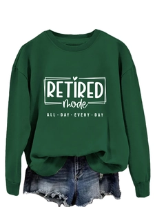Flat lay of dark green sweatshirt with Retired Mode print and ripped denim shorts set