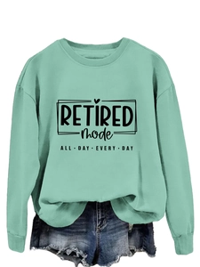 Detail of mint green sweatshirt with Retired Mode text and denim shorts on white background