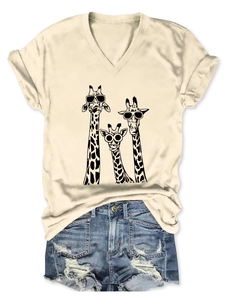 Detail view of summer T-shirt featuring three giraffes with denim shorts on white background